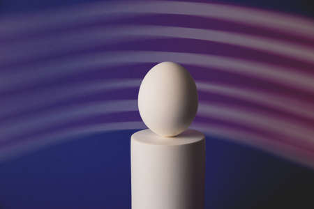 White easter egg on podium in neon and purple lightの写真素材