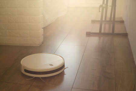 Smart robot vacuum cleaner in the interior makes cleaning of the laminate floorの写真素材