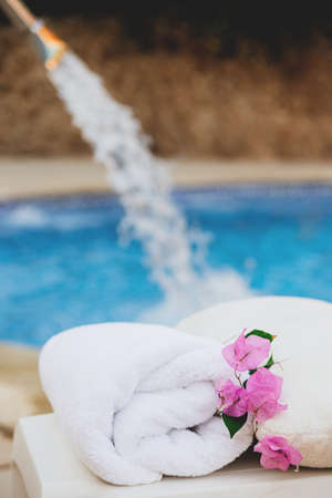 White towel with pink flowers near the spa pool in the hotel on vacationの写真素材
