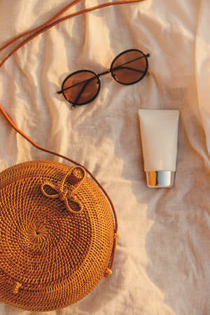 Beautiful female accessories, glasses and cream on the beach. Summer vacation resortの写真素材