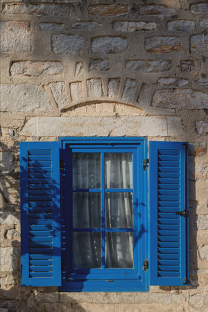 A gray building with blue window frames in the Greek style. Travel and architecture conceptの写真素材