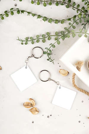 Key chain mockup to display design. Key chain mock up in cozy home design. Blank rhombus white sublimation keychain photoの写真素材