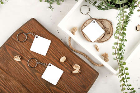 Key chain mockup to display design. Key chain mock up in cozy home design. Blank rhombus white sublimation keychain photoの写真素材