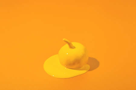 Yellow Halloween pumpkin with liquid paint flowing. Minimal Holiday season orange concept background.の写真素材