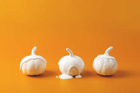 Three white Halloween pumpkins with liquid paint flowing. Minimal Holiday season concept background.の写真素材