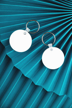 Blank round keychain mock ups on blue paper fans