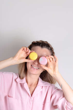 Authentic woman portrait with macarons in hands. Confectioner lifestyle photo.の写真素材
