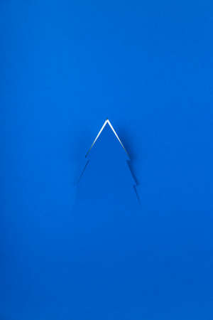 Blue minimalistic Christmas winter background with silhouette of Christmas tree.の写真素材