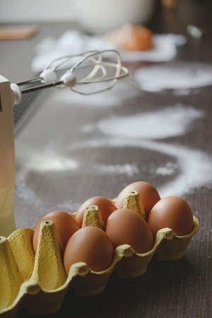 Eggs, flour and mixer in home kitchen for making pies and desserts for family.の写真素材