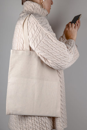 Tote bag mock up on shoulder of woman in sweater. Eco bag mockupの写真素材