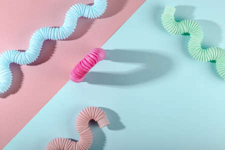 Curved pink blue mint antistress pop tube toy with shadow on pink background. Bright kid toy.の写真素材