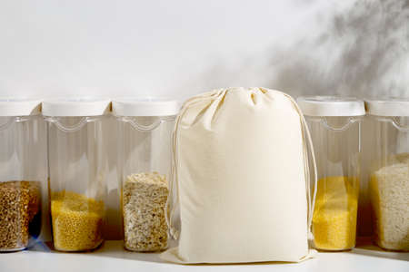 Eco food bag mock up for buying cereals in kitchen next to containers. Zero waste lifestyle.の写真素材