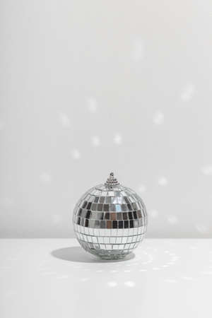 Silver disco ball reflects sunlight on silver background.の写真素材