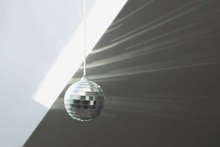 Silver disco ball reflects sunlight on silver background. Motion blur.の写真素材