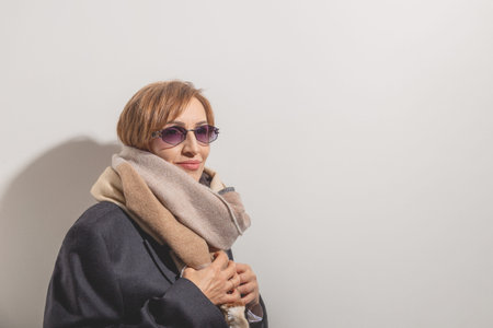 Beautiful baby boomer woman of middle age in sunglasses smile and looking away. Copy space.