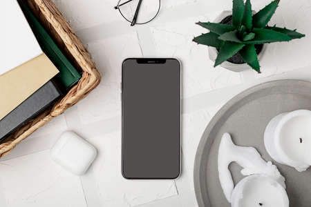 Smartphone screen mockup on stylish cozy home office workplace. Modern desktop.の写真素材