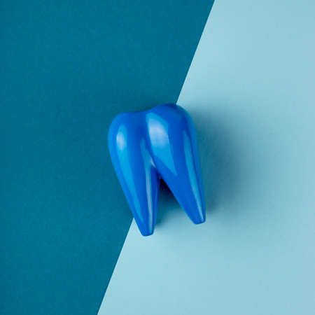 Large blue tooth lies on combined blue background.の写真素材