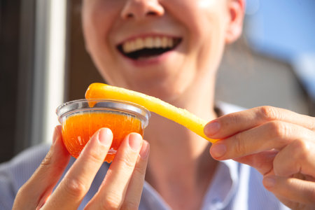 Woman is eating French fries and smiling. Junk food concept.の写真素材