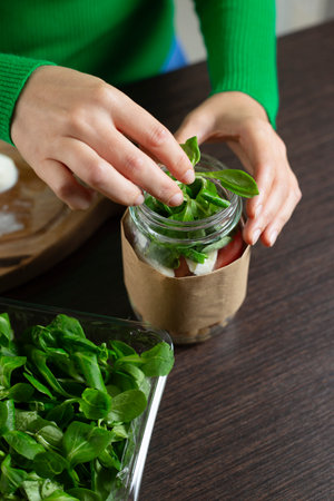Woman making vegan salad in jar with chickpea. Cooking healthy food.の写真素材