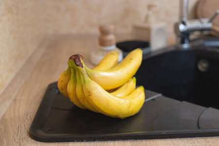 Bunch of bananas near the sink in home kitchen.の写真素材
