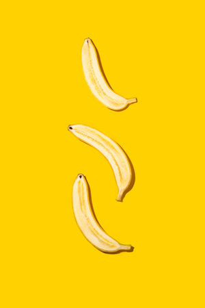 Half of bananas on bright yellow background.の写真素材