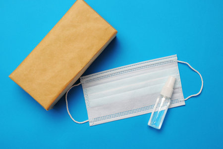 Brown closed carton delivery packaging box ,Hand sanitizer spray and surgical facial mask as...