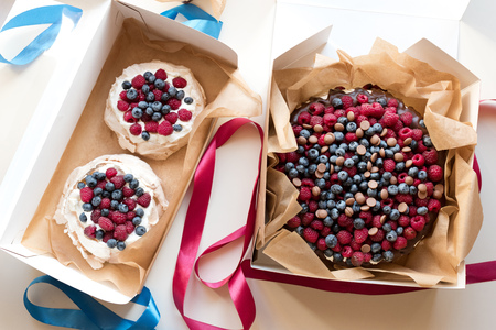 Big carrot pie with chocolate cream, blueberry, raspberry and milk chocolate drops. And two small zephyr cakes.の写真素材