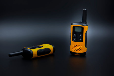 Two generic touristic Walkie Talkie Radio isolated models set right side by side in dark studio...
