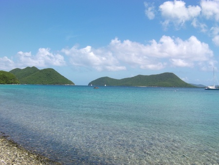 Clear Ocean Water with Mountains and Cloudy Skyの写真素材