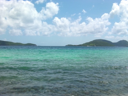Clear Ocean Water with Mountains and Cloudy Skyの写真素材