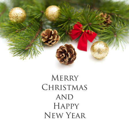 Lush branch of pine, decorated with gold glitter pine cones, shiny golden balls, and a little red bow on a white background. Christmas composition with sample text, flat lay, copy space, template for a greeting card or invitation to celebrate Christmas Eve or New Year's party.の写真素材