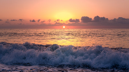 Magnificent sunset over the gentle waves of the warm tropical seaの写真素材