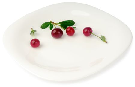 Four red ripe cherries on white plateの写真素材