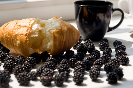 Fresh croissant and blackberries on natural white background,