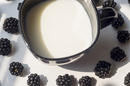Various fresh summer berries, cup of coffee on natural background.の写真素材