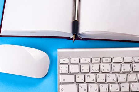 Office black desk table with white computer, business card blank, flower, coffee cup and pen.の写真素材