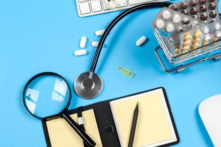 Shopping trolley with pills and medicine - medical concept. Medical report with pills and a stethoscope.の写真素材