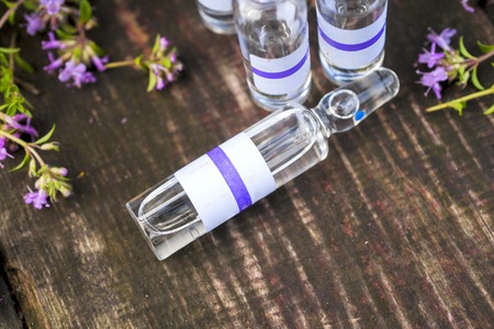 Alternative Medicine.Thyme and medical ampoules on a wooden rustic background. Essential oils and herbal supplements.の写真素材