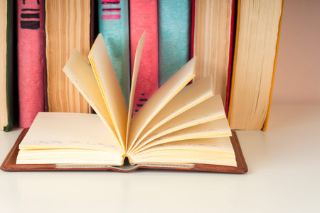 Open book, hardback books on bright colorful background.