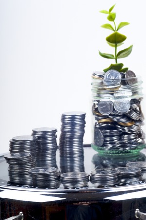coins with plant and clock, isolated on white background. savings conceptの写真素材