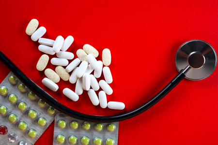 Many pills and tablets isolated on red backgroundの写真素材