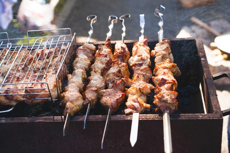 Marinated shashlik preparing on a barbecue grill over charcoal. Shashlyk was originally made of lamb. Man cookingの写真素材