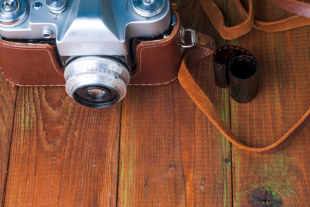 Old retro camera on vintage wooden boards abstract background. Copy space for text