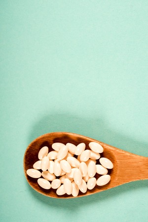 Wooden spoon with a measuring tape on a blue background, diet, healthy lifestyle.の写真素材