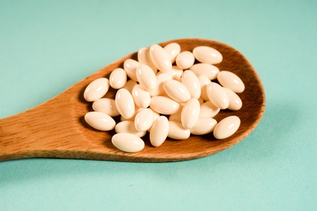 Wooden spoon with a measuring tape on a blue background, diet, healthy lifestyle.の写真素材