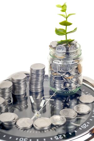 coins with plant and clock, isolated on white background. savings conceptの写真素材
