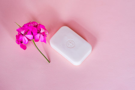 Soap bar in foam with copy space in center isolated on bright pink background.