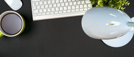 Black desk office with laptop, smartphone and other work supplies with cup of coffee. Top view with copy space for input the text. Designer workspace on desk table essential elements on flat layの写真素材