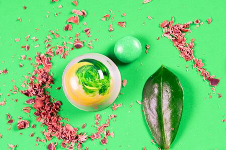 Top view of set of beautiful and delicious chocolate sweets decorated with assorted chocolate crumbs and decorated with green flowers isolated on a green background. Broken chocolate piecesの写真素材