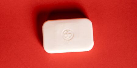 Soap bar in foam with copy space in center isolated on bright red background.の写真素材